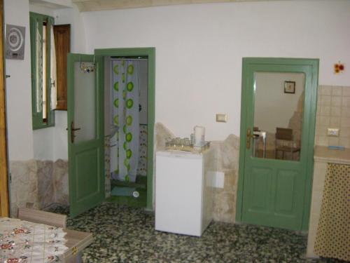 a bathroom with two green doors and a sink at La Casetta in Oria