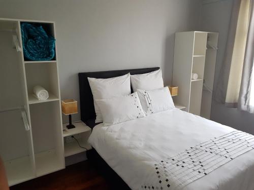 a bedroom with a white bed and white shelves at ARCHITECTs VIEW - SUIT 2 in Durban