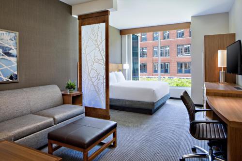 グランドラピッズにあるHyatt Place Grand Rapids Downtownのベッドとソファ付きのホテルルーム