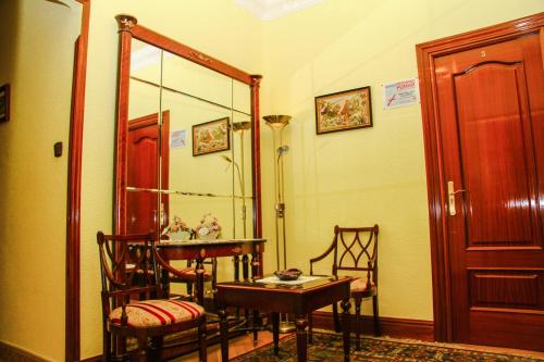 a room with a table and chairs and a mirror at Pensión Numancia in Madrid