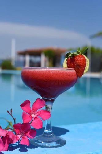 a red drink in a martini glass with a strawberry at Jessica's Studios & Apartments in Kavos