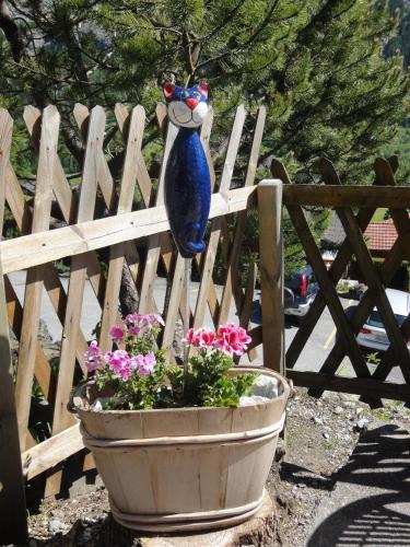 a vase hanging on a fence next to a flower pot at Lehmann's Herberge Hostel in Grindelwald