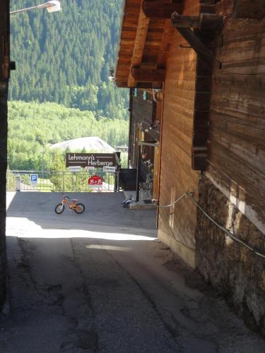a bike parked next to a building with a tent at Lehmann's Herberge Hostel in Grindelwald