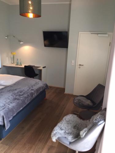 a bedroom with a bed and a chair and a desk at Trafohaus am Kaiserbahnhof in Brühl