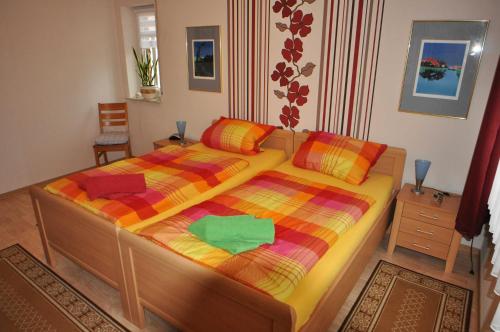 a bedroom with a bed with a colorful comforter at Ferienwohnung Anni, 65325 in Moormerland