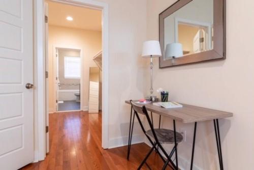 Habitación con mesa, espejo y baño. en Beautiful Lux 4 Bedroom*Near PENN/CHOP*Roof Deck, en Filadelfia