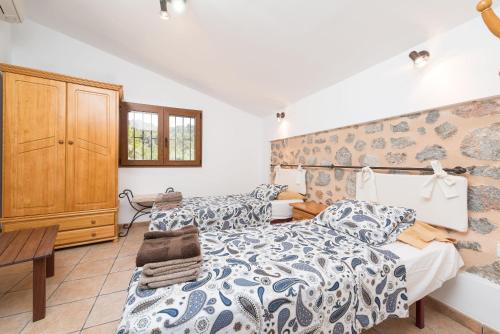 a bedroom with a bed and a wooden cabinet at Dos Villas in Sóller
