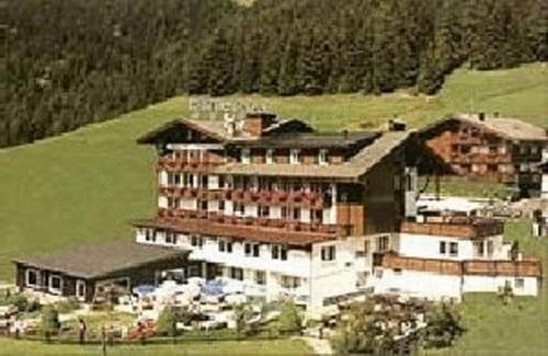 a large building on top of a green hill at Family & Wellness Hotel Fontana in Vigo di Fassa