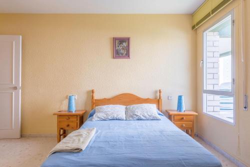 エル・プエルト・デ・サンタマリアにあるApartamento Bahía Luzのベッドルーム1室(青いベッド1台、ナイトスタンド2台付)