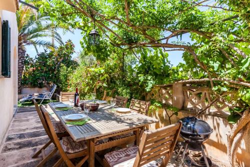 a table and chairs on a patio with a grill at Casa Mediterranea Invierno in Cala Llombards