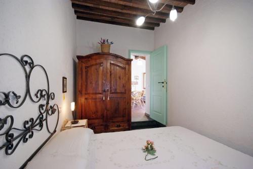 a bedroom with a bed and a wooden cabinet at Il Villino Isola d'elba-ortano in Rio nellʼElba