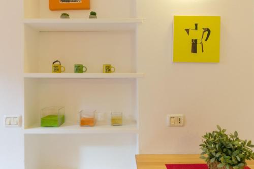 a room with white shelves and a yellow picture on the wall at Monolocale casa Lucia in Campo nell'Elba