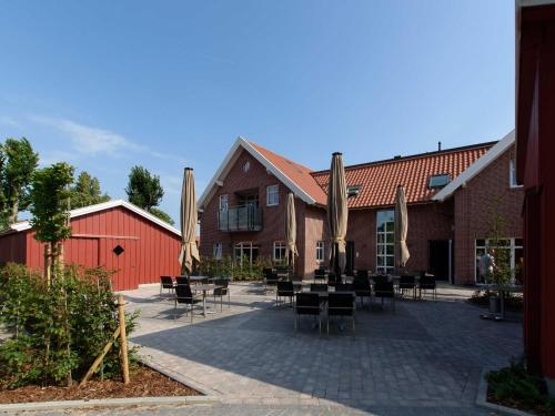 a patio with tables and chairs in front of a building at Sielhof Ditzum, 45222 in Ditzum