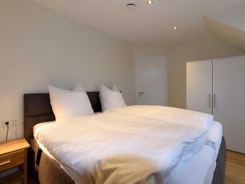 a large white bed with white sheets and pillows at Sielhof Ditzum, 45222 in Ditzum