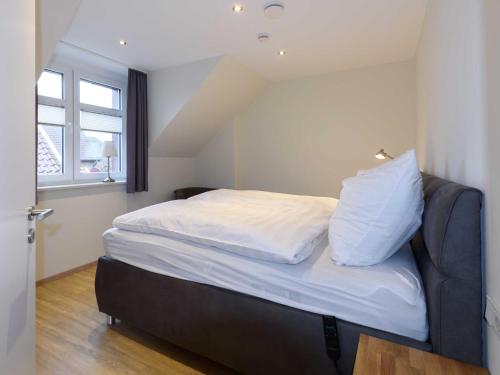 a bedroom with a bed with white sheets and a window at Sielhof Ditzum, 45222 in Ditzum