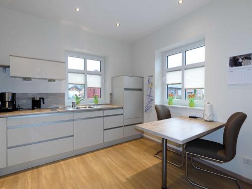 a kitchen with white cabinets and a wooden table at Sielhof Ditzum, 45222 in Ditzum