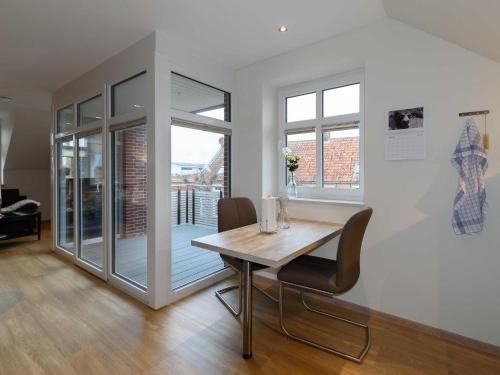 a dining room with a wooden table and chairs at Sielhof Ditzum, 45222 in Ditzum