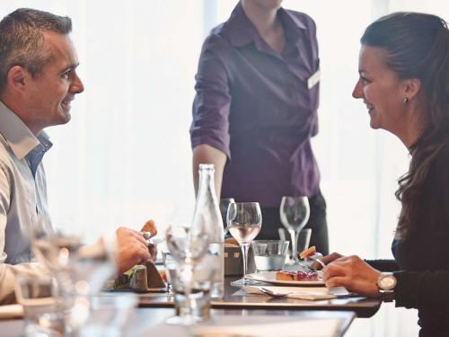 a group of people sitting at a table with wine glasses at The Novotel Toronto Centre in Toronto