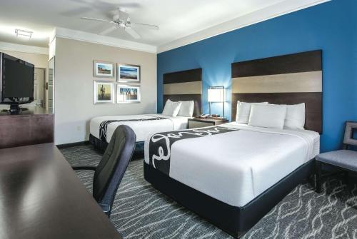 Habitación de hotel con 2 camas y TV de pantalla plana. en La Quinta by Wyndham Phoenix I-10 West, en Phoenix