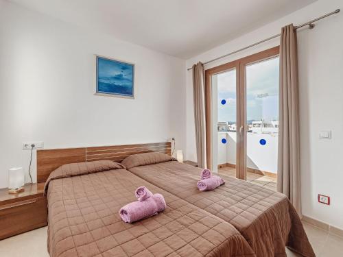 dois bichos de peluche cor-de-rosa sentados em cima de uma cama em Montevela em Cala d´Or