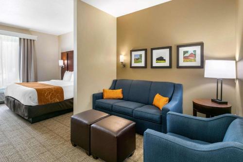 a hotel room with a bed and a blue couch at Comfort Suites Hopkinsville near Fort Campbell in Hopkinsville