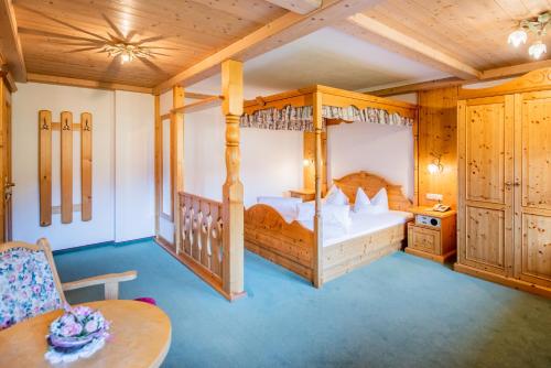 1 Schlafzimmer mit 2 Etagenbetten, einem Tisch und einem Stuhl in der Unterkunft Hotel Winklerhof in Holzgau