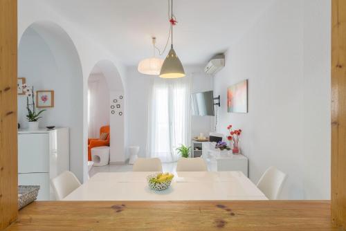 a white dining room with a white table and chairs at Apartamento Bateles in Conil de la Frontera