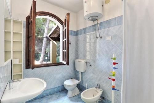 a bathroom with a sink and a toilet and a mirror at Villa Artistica app.1/trilo 6 (trilocale) in Capoliveri