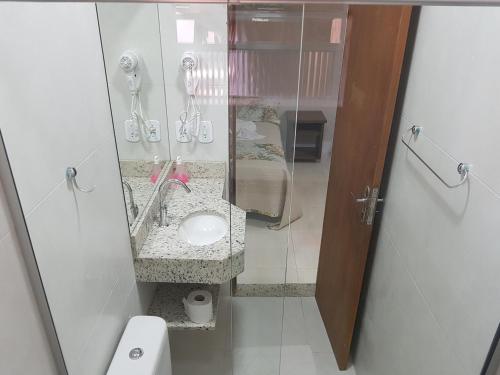 a bathroom with a sink and a shower stall at Hotel Refugio in Bonito