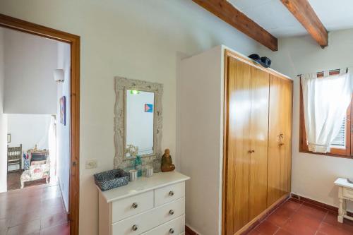 a bedroom with a dresser and a mirror on the wall at Villa Estrella Fugaz in Binibeca