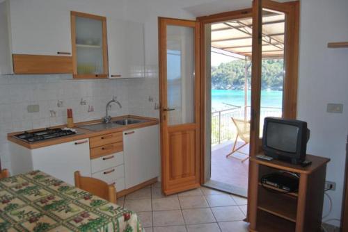 a kitchen with a sink and a tv in a room at Appartamenti Fetovaia Elicriso in Fetovaia