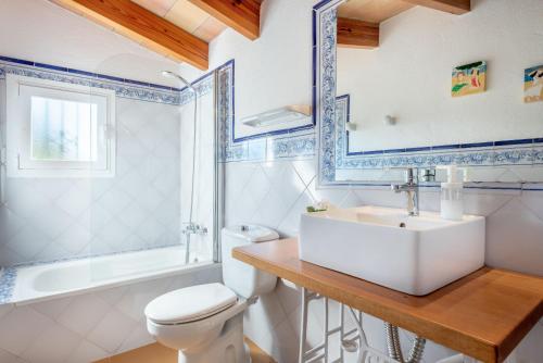 a bathroom with a sink and a toilet and a tub at La Sorteta De Cuxach in Pollença