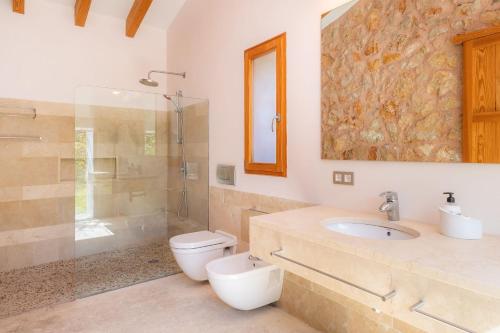a bathroom with a toilet and a sink and a shower at Sa Plana in Son Servera