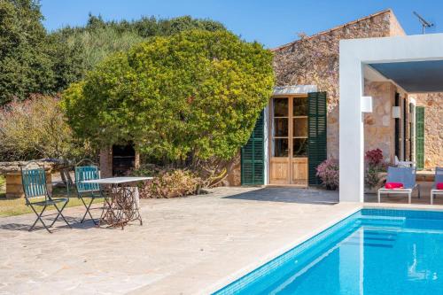 a patio with a table and chairs next to a pool at Sa Plana in Son Servera
