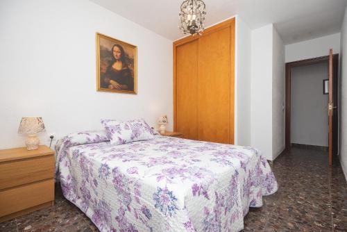 um quarto com uma cama e uma fotografia na parede em Apartamento Ramón em Conil de la Frontera