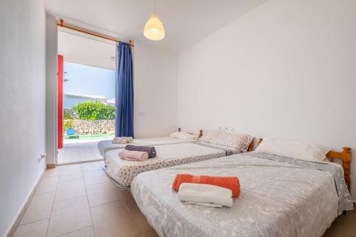 two beds in a room with a large window at Villa en Menorca in Mahón