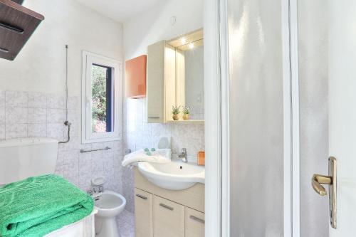 a white bathroom with a sink and a toilet at Il giardino nel sole Trilo in Capoliveri