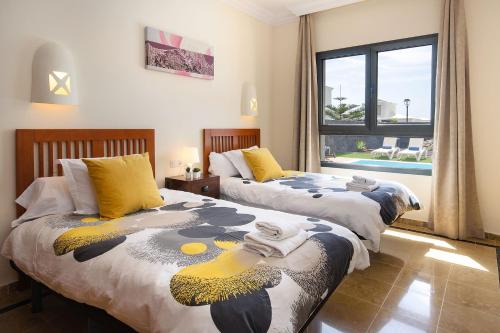 Dos camas una al lado de la otra en un dormitorio. en Aguamarina 4, en Playa Blanca