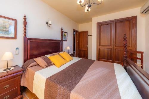 a bedroom with a large bed with yellow pillows at Cas Pobler in Manacor