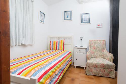 a bedroom with a colorful bed and a chair at Can Guixa in Sóller