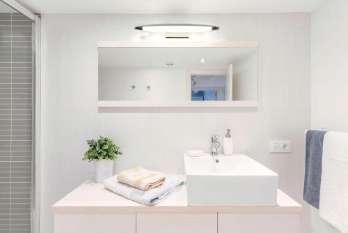 een witte badkamer met een wastafel en een spiegel bij Luminoso apartamento en el centro de Cádiz in Cádiz