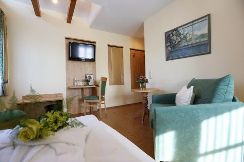 a living room with a blue couch and a table at Landhotel Villa Moritz garni in Oberahr