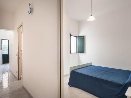 a bedroom with a blue bed in a white room at Villa Tetta sul mare in Torre Lapillo