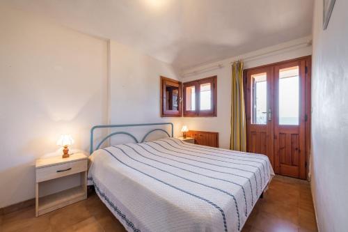 a small bedroom with a bed and a window at Accu is prezzus I 30mt dal mare in Villasimius