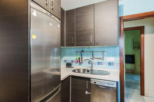 a kitchen with a sink and a refrigerator at La Tahona de Max&jan in Conil de la Frontera