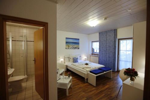 a bedroom with a large bed and a bathroom at Landhotel Villa Moritz garni in Oberahr