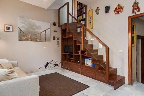 a living room with a wooden staircase in a house at La Tahona de Max&jan in Conil de la Frontera