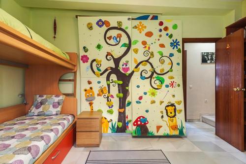 a bedroom with a tree mural on the wall at La Tahona de Max&jan in Conil de la Frontera