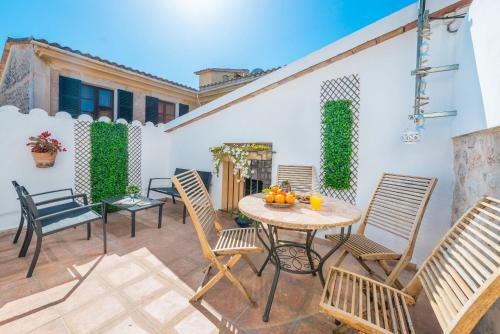 a patio with chairs and a table with oranges on it at Sa Fusteria in Sóller