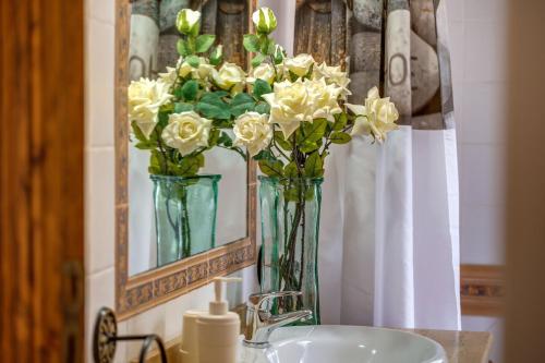 a bathroom with two vases with flowers on a sink at Dosmadres7 in Llucmajor